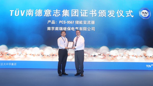 美國儲能系統(tǒng)技術(shù)委員會主席、TUVSUD全球風(fēng)險顧問公司常務(wù)顧問JamesBiggins（右）為南瑞繼保的產(chǎn)品儲能變流器PCS-9567頒發(fā)TUVSUD證書